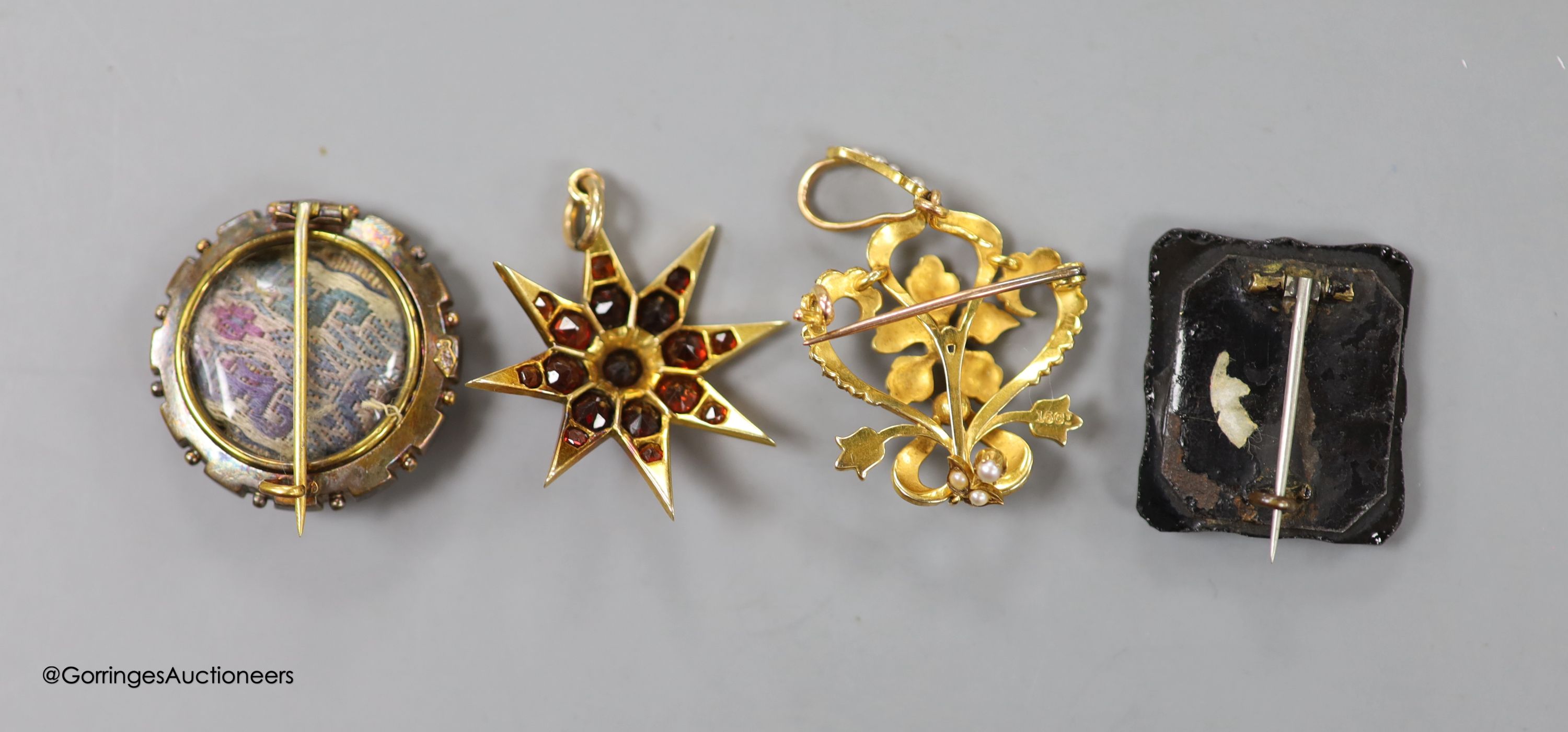 An Edwardian 15ct and seed pearl set drop pendant brooch, overall 48mm, gross 6.4 grams, a Victorian yellow metal target brooch, gross 5 grams, a Victorian yellow metal and a similar graduated garnet set starburst brooch